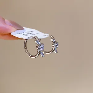 Macro view of 14K gold plated cubic zirconia knotted hoop earrings with label