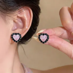 Detailansicht der herzförmigen Ohrringe mit rosa Stein und schwarzem Zirkonia-Rahmen