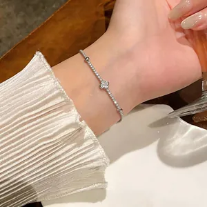 Dettaglio ravvicinato di un braccialetto di fiori d'argento con zirconi sul polso di una donna