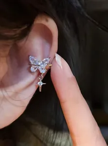 Detailed view of exquisite zircon butterfly ear cuff with star charm worn on the ear bone