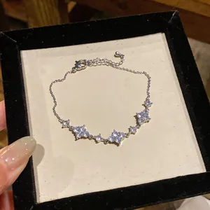 Primo piano di un bracciale in argento scintillante con tre fiori di zirconi