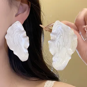 Detailed view of vintage-style pearl-white drip oil leaf stud earrings