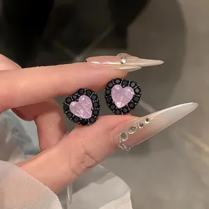 Detaillierte Ansicht von herzförmigen Ohrringen mit rosa Mitte und schwarzem Zirkonia-Rand.