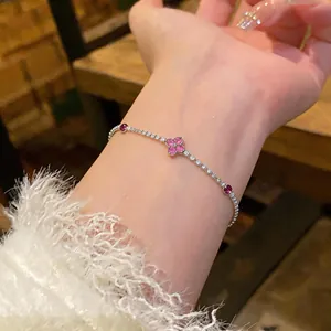 Dettaglio macro di un bracciale in argento con fiori di zirconi scintillanti al polso