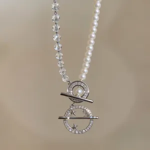 Detailed view of elegant necklace with pearls, crystals, and star-shaped zircon pendants.