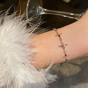 Dettaglio di un delicato braccialetto con fiori di zircone colorato sul polso femminile