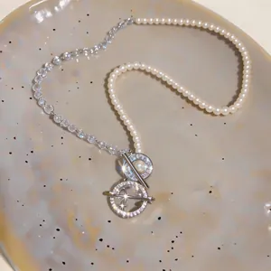 Macro view of elegant zircon pearl beaded necklace with star pendant on ceramic plate