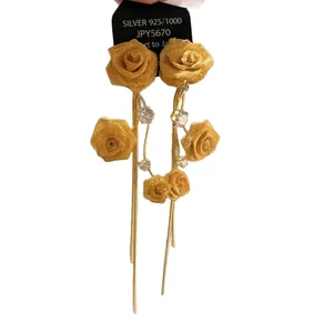 Elegant gold fabric rose tassel earrings with shimmering cubic zirconia accents.