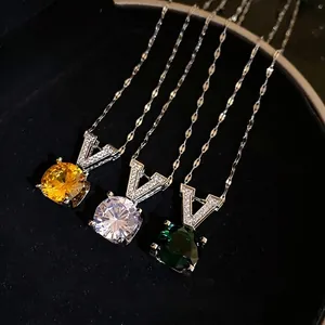 Collier élégant en V avec zircone et pierres facettées rondes jaunes, claires et vertes.