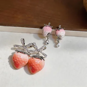 Detail shot of sweet resin strawberry earrings featuring sparkling zircon drop pendants