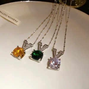 Vue détaillée de trois colliers à pendentif V en zircon rond, coloris jaune, vert et blanc