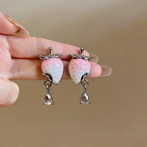 Close-up of sweet resin strawberry earrings with sparkling zircon teardrop pendants.