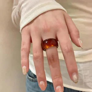 Bague épaisse en résine ambre vintage avec une finition translucide sur la main