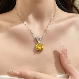 Détail d'un collier argenté avec pendentif en V et un grand zircon jaune étincelant.