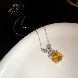 Vue rapprochée de l'élégant pendentif V en argent avec une pierre de zircon jaune vif.