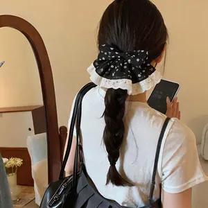 Elegante zwarte bloemen strik haarclip met witte kant op een gevlochten kapsel