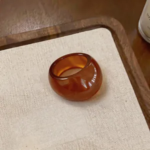 Gros plan détaillé d'une bague ovale en résine ambrée au style Maillard vintage chic