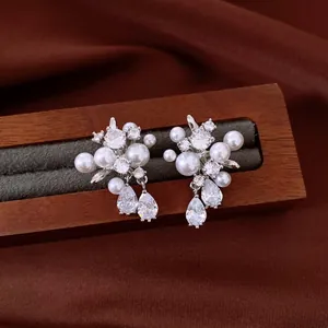 Detail of elegant earrings featuring white pearls and sparkling pear-cut cubic zirconia