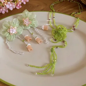 Handmade green beaded flower tassel jewelry set featuring floral necklace and earrings