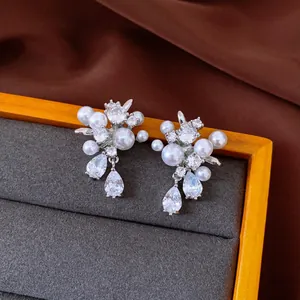 Detailed view of elegant silver earrings featuring lustrous pearls and sparkling zircons