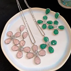 Detailed view of resin flower necklace and earring sets in green and pink colors