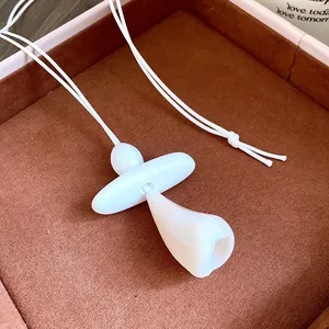 Macro view of unique white resin tooth-shaped pendant on leather cord