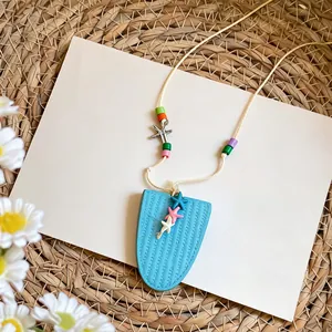 Detalle de un collar de cuentas con estrellas de mar de colores y colgante azul