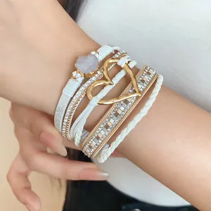 Detailed view of white multi-layer bracelet with heart charm and druzy stone on wrist