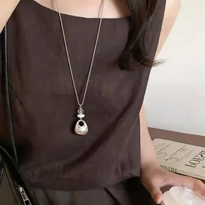 Geometric silver-tone pendant long chain necklace shown as a stylish fashion accessory