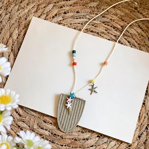 Detalle de cuentas coloridas y colgantes de estrella de mar en un collar estilo playero
