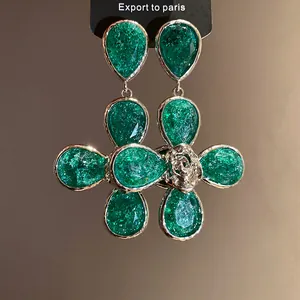 High-quality detail view of elegant green resin drop earrings with floral texture