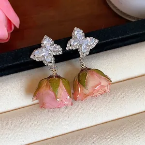 Elegant S925 silver butterfly earrings featuring a natural pink preserved rose bud