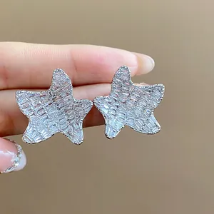 Detail view of sparkling silver star stud earrings with micro-pave cubic zirconia