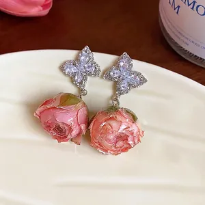 Elegant silver butterfly earrings with sparkling zircons and pink eternal dried rose flower pendants