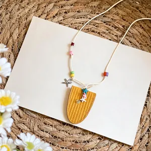 Primer plano de un collar de cuentas coloridas con dijes de estrella de mar y colgante amarillo.