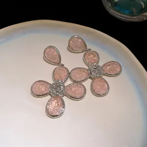 Detailed macro view of elegant pink resin flower jewelry pieces on a ceramic tray