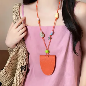 Primer plano de un collar de cuentas de colores con amuleto de estrella de mar y colgante naranja