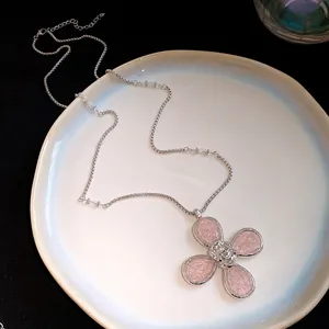 Close-up detail of silver necklace with pink textured resin flower pendant