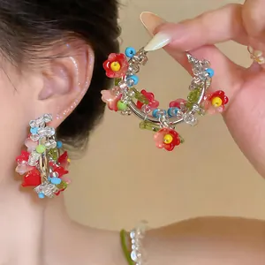 Macro view of ethnic style colorful beaded flower hoop earrings with silver needles