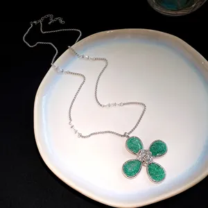 Detailed view of green resin flower pendant necklace with silver adjustable chain