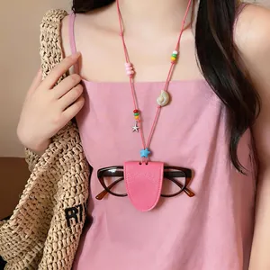 Detalle de soporte para gafas en cuero rosa con cuentas de colores en cordón.