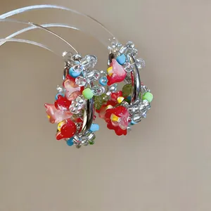 Detailed macro shot of ethnic style colorful beaded hoop earrings with red flowers