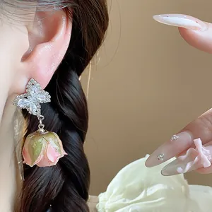 Elegant silver needle butterfly zircon stud earrings with a pink dried rose bud drop
