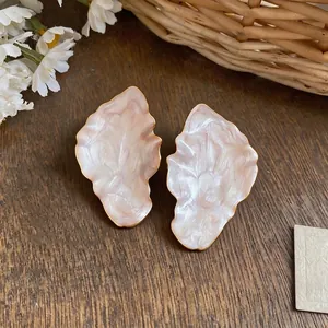 Oversized minimalist irregular leaf-shaped pearlescent stud earrings with golden metal frame