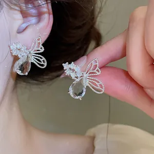 Gros plan de boucles d'oreilles papillon avec zircon en goutte et ailes ajourées