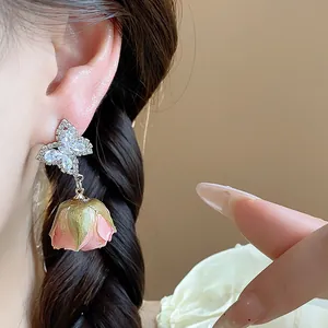 Macro view of S925 silver needle butterfly earrings featuring a real pink eternal rose