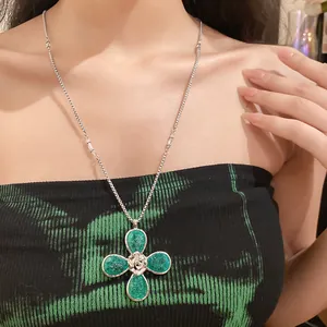 Close-up detail of a green wrinkled resin flower pendant necklace worn by a model