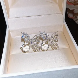 Gros plan de boucles d'oreilles papillon en zircone brillant dans un écrin à bijoux de luxe blanc