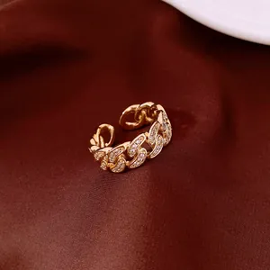 Close-up of 14k gold plated chain ring with sparkling zirconia stones on red fabric