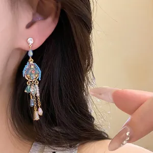 Vintage-style shell and pearl drop earrings shown on an elegant model's ear for luxury look